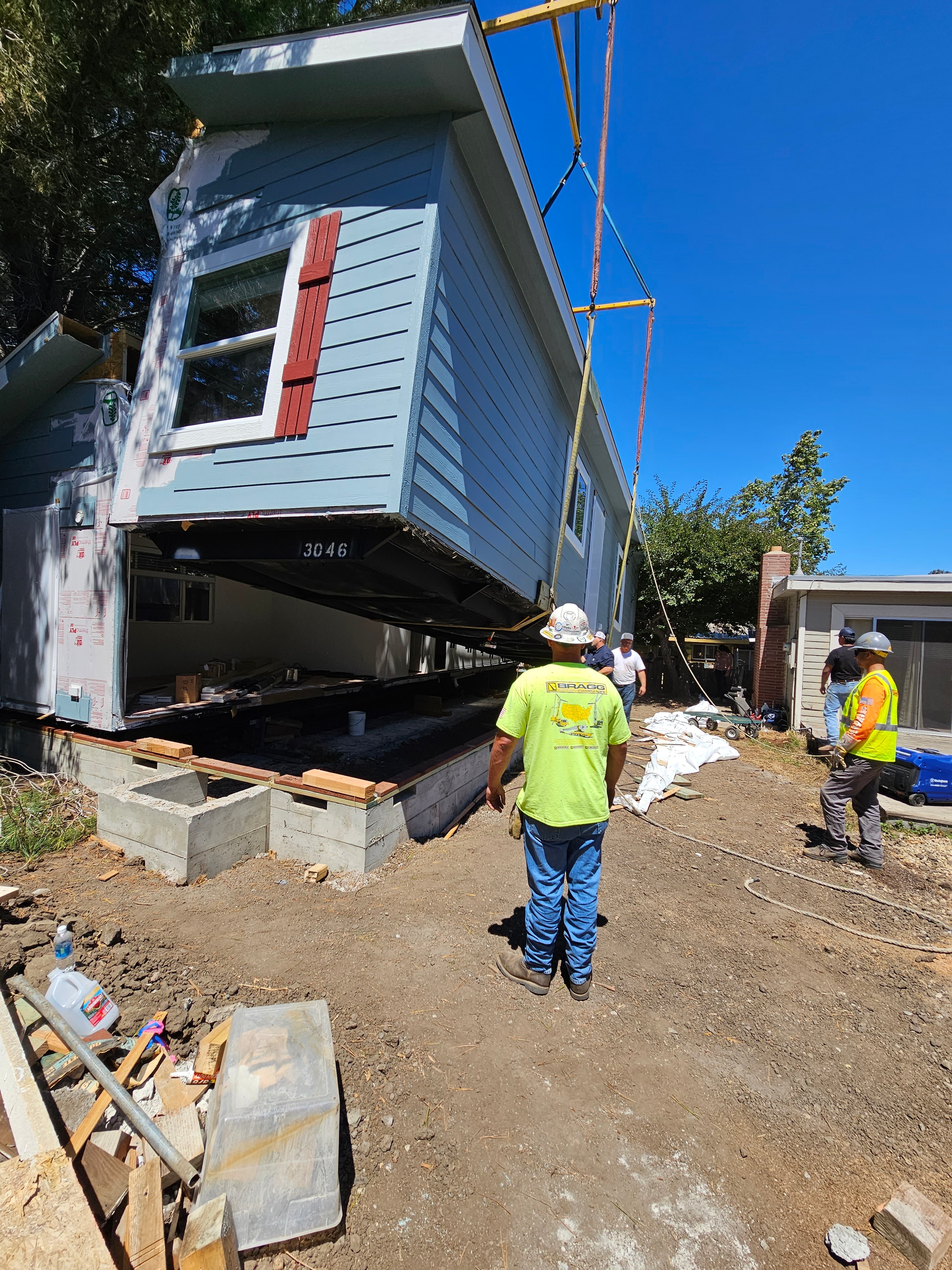 Crane placing home into backyard